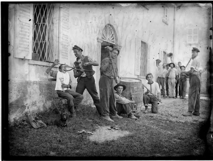 Roberto Donetta, Scène apprêtée ; groupe d’hommes devant un bâtiment, 1900-1932/1993. Courtesy